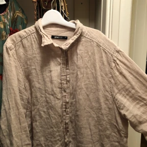  - En beige skjorta i storlek 42. Passar dock mig som är en 36/38.