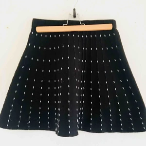  - Stickad kjol med vita detaljer i, utsvängd passform 