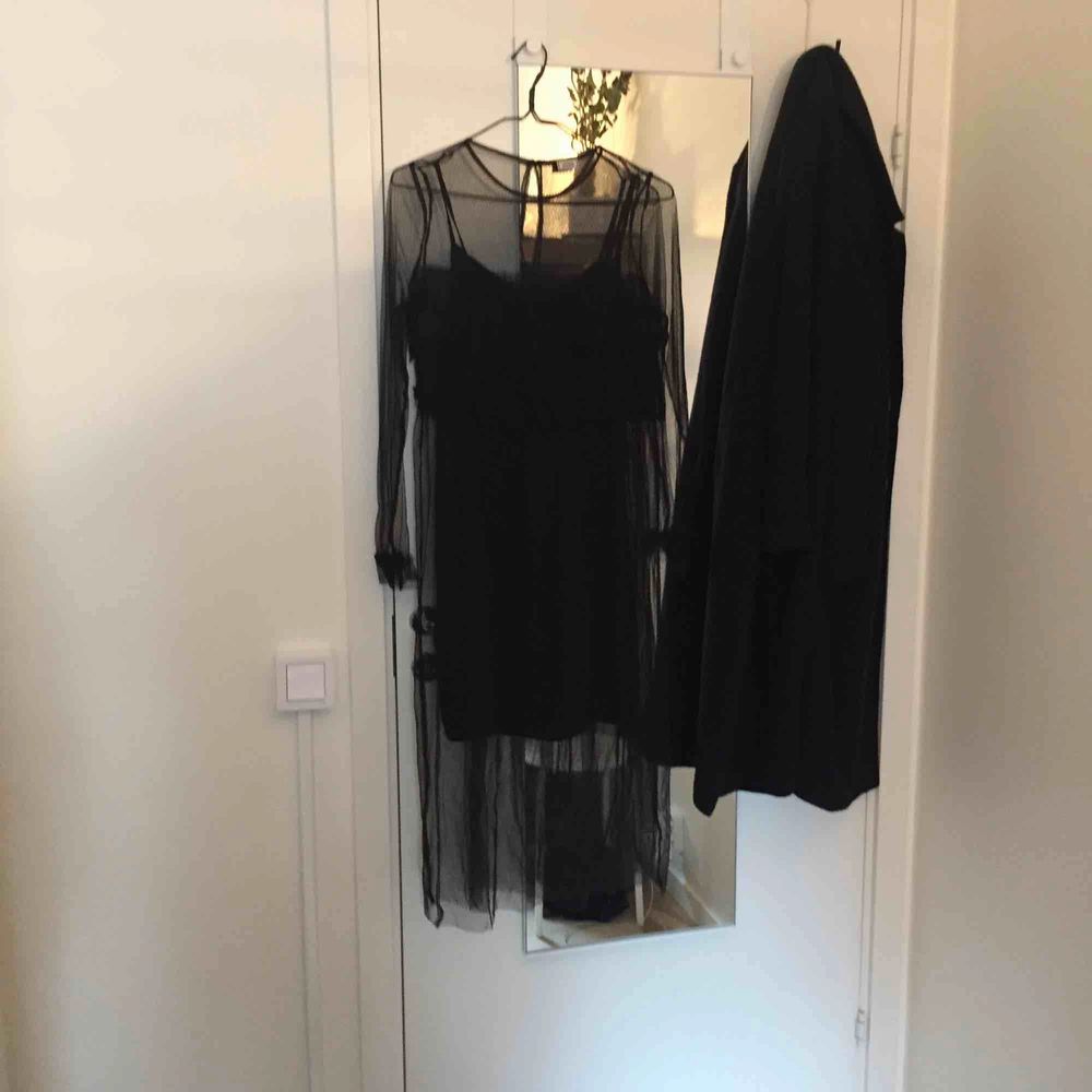 svart supercool klänning i fisknätsmönstrad mesh och inkluderad underklänning. volanger vid byst och ärmslut. endast använd två ggr, perfekt skick.. Klänningar.