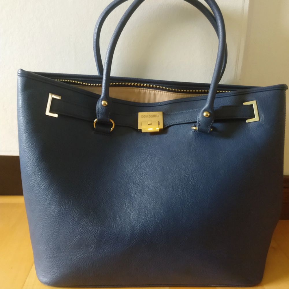 Stor mörkblå handväska i stilren modell. Man får plats med allt och den passar i de flesta sammanhang, ett kap helt enkelt! (Använd men i gott skick). Väskor.