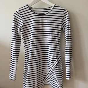  - En kort randig klänning i lite elastiskt bomull. Passar mer XS för den är så kort men skulle funka på en s. Använd en gång :-)