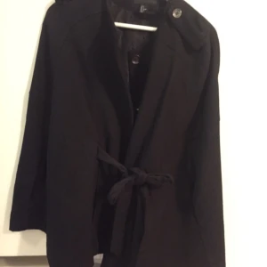  - Fin ponchojacka med snörning i midjan som skapar en figur. Endast använd ett fåtal gånger. Storlek S 