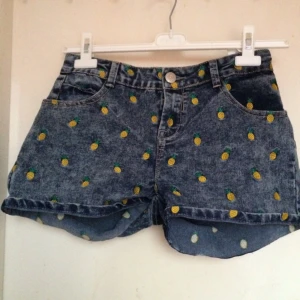  - Shorts med broderad ananas över hela. Mörk blå/grå tvätt. Använda max fem gånger. Står ingen storlek men uppskattar att de är runt en 38, dock relativt stretchiga. 

Pris diskuterbart, kan mötas runt Malmö eller skicka på posten. 