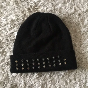  - Svart mössa med silvriga detaljer