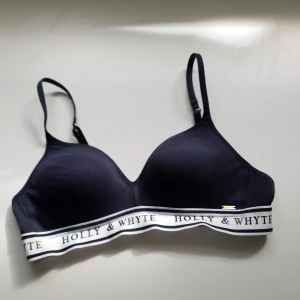 Bh utan bygel - Mörkblå Bh utan bygel i mjukt tyg som sitter bra, med ett snyggt  brett band under med märket. Lätt att justera. Fint skick och nästan oanvänd. Buda för annat pris.                                                                     Frakt tillkommer.