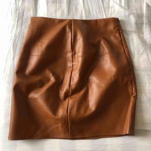 Fake brun läderkjol i strl 32 från Missguided