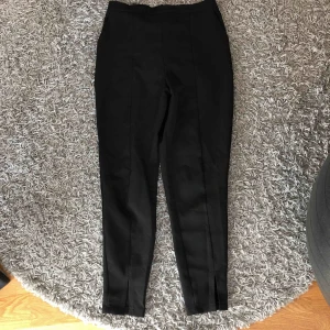  - Kostymbyxor med slits, finns fickor där fram. En dragkedja där bak som är lite trög, men den funkar. Storlek 36. 40 kr + frakt