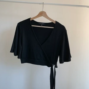 Omlott topp - Säljer denna snygga omlott topp med knytdetalj, strl 42. Skriv om du är intresserad eller undrar något💕