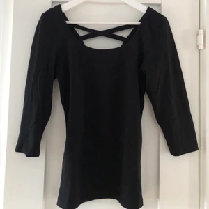 Svart långärmad tröja med bar rygg - Svart långärmad tröja med bar rygg. Storleken är i L men skulle även säga att det passar M då den är tight. Även urringning framtill. Använd 2 gånger. Står ej för frakt  
