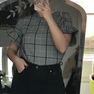 Svartvit rutig topp från Vero Moda - Svartvit rutig topp från Vero Moda med volang-armar! Storlek xs men passar även s. 