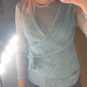 Glittrig blus - Köpt på second hand. Hade inlägg i axlarna men de har klippts bort, syns ej på utsidan (skicka för fler bilder). Köpte den för ca 200kr och den är i bra skick. Frakt tillkommer!⚡️