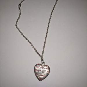Halsband med ett hjärta som innehåller text i rött. Alla smycken ta 3 betala för 2. Billigaste på köpet.