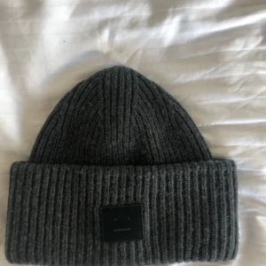 Acne mössa fint skick  - Säljer acne mössa köpt från NK i en mörk grå färg som inte säljs längre. Knappast använd och är i ett fint skick🥰🥰🥰kan mötas upp eller fraktas som köparen står för priset!