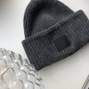 Acne mössa - Acne mössa köpt på NK i enligt mig den finaste grå färgen! Köpt för 1100 och väldigt lite använd! Högsta bud 660kr!