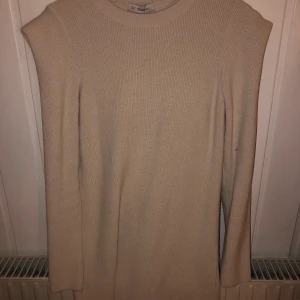 Klänning  - Ljus beige/vit klänning! Går till knän typ, kan välja lite själv! Jätte fint skick! Använd 1 gång! Axel detaljer! Från chiquelle! 