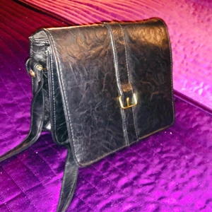 Svart superpraktisk skinnväska - Medelstor praktisk väska i svart läder. Med många funktionella och praktiska fack. Mobil/kameraficka. Spegel i locket. Myntfack. Plats för kreditkort. Sedelfack. Plats för id alt fotografi.