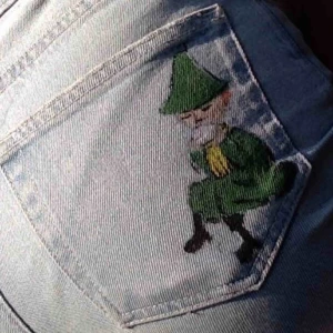  - Ljusblå vida jeans med ett påmålat snusmumrik tryck på bakfickan. Köpta secondhand, xs motsvarar ca en 25-26 i jeansstorlekae