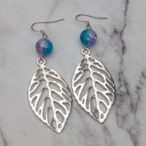 Silver leaf  - Fina silverfärgade örhängen med tvåfärgade glaspärlor och stora löv. Nickelfria. 11:- i frakt, fri frakt vid köp över 100:-.