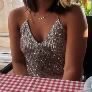  - Angel_E’s bud: 160 kr. Champagne-färgad Paljett-topp i strl L som sitter som xs-s från Zara. Har klippt av banden så att man kan knyta den själv i nacken och få en strapless rygg. (Frakt tillkommer)