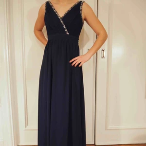  - Marinblå balklänning i mycket fint skick. Använd två gånger. Superfin rygg med ett trasigt spänne som lätt går att laga. Vill gärna att denna ska få ett nytt liv då den inte kommer till användning för mig. 