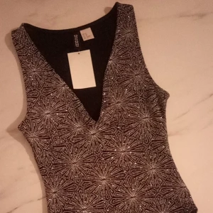  - Glittrig body i XS. Oanvänd! 