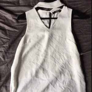  - Sparsamt använd topp/blus med chokerkrage Små slits på vardera sida