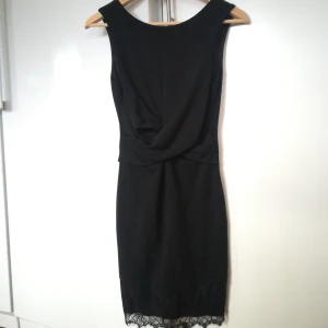  - Svart festklänning med spets nertill, mycket sparsamt använd.