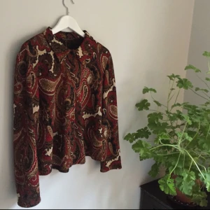  - Fantastiskt fin retroskjorta i toppskick. Paisleymönstrad i härligt murriga färger, samt en öppning i ryggen som verkligen gör skjortan speciell.   ✨Hämtas i Karlskrona // Frakt betalas av köparen  Priset kan eventuellt diskuteras✨