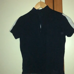 Mörkblå tröja - En mörkblå bikertröja från monki. Den är lite croppad och har ganska korta ärmar. 