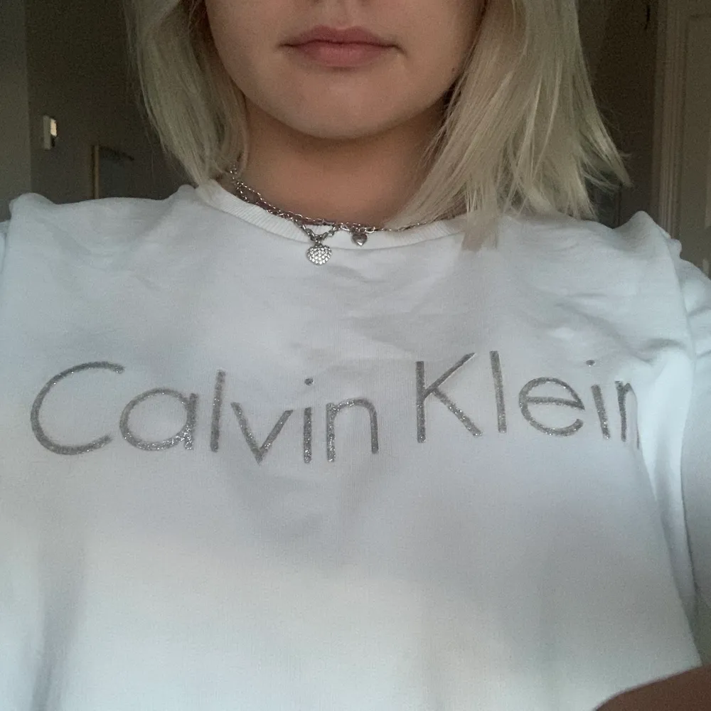 Så fin sweater från Calvin Klein i glittrig text. Har tyvärr fått en fläck vid magen men inget jag lagt märket till när jag använt den. . Tröjor & Koftor.