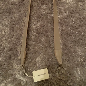 Väskband - Vitt väskband från Carin Wester, aldrig använt och har alla lappar kvar💞 Kan skickas om köparen står för frakten.