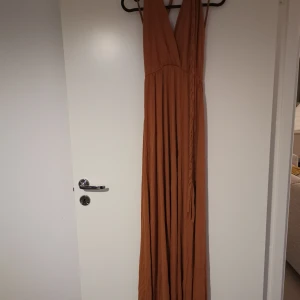 Långklänning  - Fint skick. Använd 1 gång. Sprund i mitten framtill. Kan passa från XS till M pga av tyget. 