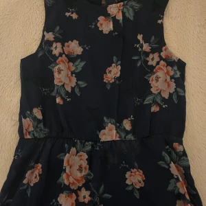 Mörkblå blommig klänning💙 - Supersöt mörkblå klänning med stora blommor i rosa och med gröna blad. Perfekt för sommarens alla tillfällen. Tunn och luftig, med snyggt fall. Säljer den pågrund av att den inte passar min stil längre. Priset ser ni där men priset kommer ligga ungefär på 150-200kr annars kan priset diskuteras. Storleken är 152,men den passar xs och s eftersom klänningen är ganska stor💙