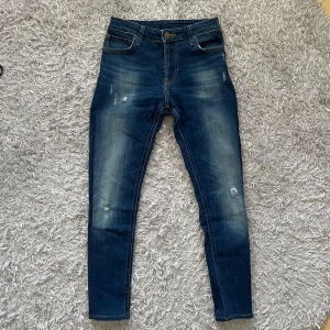 Jeans med slitningar  - Ett par sköna jeans från märket Lee! | Mycket fint skick på jeansen, slitningarna är del av designen. | Storleks lappen säger w30 l32 men dom sitter betydligt mindre, skulle säga att de passar någon omkring 160-165 men fråga gärna om mått för säkerhetsskull! | Ställ gärna frågor innan du köper!