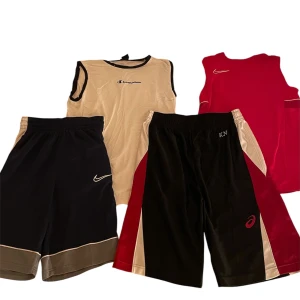 Träningskläder - Två par sportiga shorts, ett par från Nike i svart med grå detaljer i storlek XS/S och ett par från Asics i svart med röda och beige paneler i storlek S/M. Båda shortsen passar dig som vill ha en avslappnad stil. Två linnen också, en från Champion i vitt med svarta detaljer i storlek 162/167cm och en från Nike i rött med vita detaljer i storlek 147-158cm. Kontakta mig så att vi kan bestämma ett rimligt pris för artikeln du tänker köpa, du kan också välja att köpa allt ihop för bara 500kr.