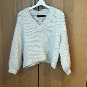 Vit stickad v-ringad tröja från Vero Moda - Mysig vit stickad tröja från Vero Moda med v-ringning och lång ärm. Den har ganska mycket tecken på användning, den är nopprig och några trådar sitter löst💗