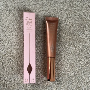 Charlotte Tilbury Pillow Talk Beauty Light Wand Highlighter - Highlighter i nyansen Pillow Talk Medium från Charlotte Tilbury. Kommer i en tub med roséguldfärgat lock och rymmer 12 ml. Perfekt för att ge glow till kindben och ansikte. Säljs med originalförpackning. Den är lite mer en halv full