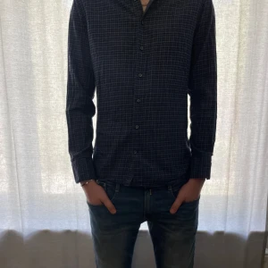 Mörkblå rutig skjorta från Stenströms - Säljer nu min pojkväns skjorta från Stenströms i modellen Fitted Body då den är för liten. Han är 195 cm och det är storlek 41 på skjortorna som motsvara ungefär storlek L. Skjortan har långa ärmar, klassisk krage och knäppning framtill. Perfekt för dig som gillar en stilren och tidlös look.