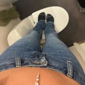 Mörkblå lågmidjade jeans - Säljer ett par mörkblå jeans med låg midja bootcut och klassisk femficksdesign. Jeansen har en rak passform och är tillverkade i denim med lätt slitning. Perfekta för dig som gillar en tidlös och enkel stil. Passar långa ben (174) , För smal i midjan för mig