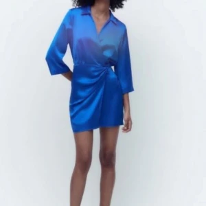 Blå omlottklänning i satin från Zara - Säljer en snygg blå omlottklänning i satin från Zara. Aldrig använd med prislapp på🤍