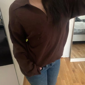 Brun stickad tröja från Gina Tricot - Brun stickad tröja från Gina Tricot med v-ringning och krage. Tröjan är i strl (M), Skriv via dm vid funderingar 💬🤎