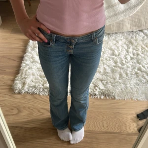 Lågmidjade blå bootcut jeans💙 - Snygga blå bootcut jeans med flera knappar i midjan! Storlek 152 men passar mig som är 160💙