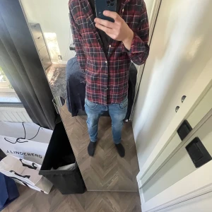 Rutig skjorta från Polo Ralph Lauren - Säljer en klassisk rutig skjorta från Polo Ralph Lauren i mörkblått, rött och vitt. Skjortan har lång ärm, knappar framtill och broderad logga på bröstet. Perfekt för dig som gillar tidlös stil.