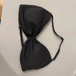 mörkgrå sport bh  - Säljer en mörkgrå sportbh med enkel och stilren design. Överdelen har trekantsformade kupor och smala axelband. Perfekt för träning