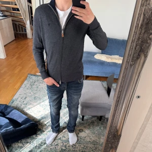 Mörkgrå ziptröja från Morris - Riktigt snygg fullzip från Morris med riktigt bra passform, säljer för jag växt nu ur den men har hållit den i mycket bra skick. Skriv med funderingar