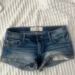 lågmidja jeansshorts från Hollister - Snygga blå jeansshorts från Hollister med slitna detaljer. Storlek w26 eller XS-S!