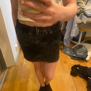 Snygg svart jeanskjol med resårmidja💞 - Säljer en svart jeanskjol med resår i midjan och knapp framtill. Kjolen har fickor fram. Perfekt till vardags för en cool och avslappnad look! Katt finns i hemmet ❣️