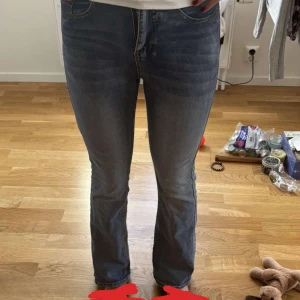 Blå bootcut jeans med broderade fickor - Säljer ett par blå jeans med bootcut-modell och snygga broderade bakfickor. Jeansen har klassisk femficksdesign, normal passform och är tillverkade i mjukt denimtyg. Perfekta för dig som gillar en tidlös look med lite extra detaljer. Min kompis på bilder är 170ungefär har aldrig använt dom bara provat!