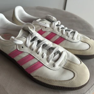 Adidas Samba OG Women  - Knappt använda och i jättebra skick. Kan skicka fler bilder. Skickar gärna via Blocketpaketet. Finns annars i Helsingborg. Mer info: Låga sneakers Cloud White/wonder white design med rosa detaljer Ovandel i läder och mocka Mjuk mellansula i skum Greppande yttersula i gummi Vadderat ankelparti adidas Originals-logga och 3-Stripes