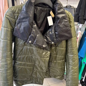 Olivgrön pufferjacka från Cocomore - Snygg olivgrön pufferjacka från Cocomore med stor svart krage och coolt emblem på ärmen. 